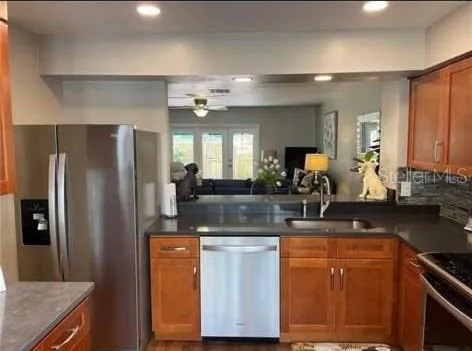 a kitchen with stainless steel appliances granite countertop a sink a stove and a refrigerator