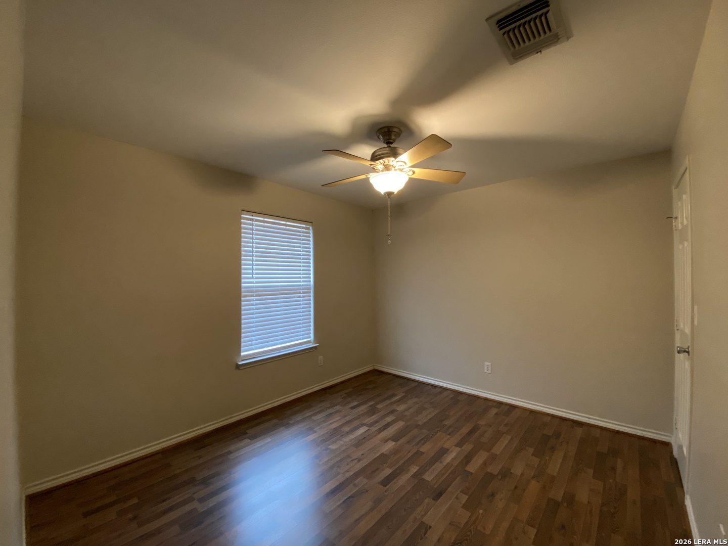 108 Ocotillo Jourdanton, TX 78026 - Photo 11 of 14 a view of an empty room with wooden floor and a window