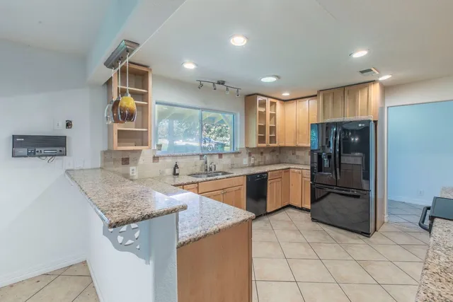 a kitchen with stainless steel appliances granite countertop a sink stove and refrigerator