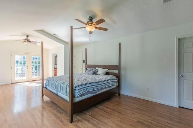 a bedroom with a bed and wooden floor