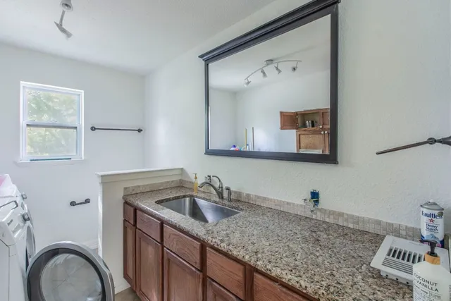 a bathroom with a granite countertop sink a toilet and a mirror