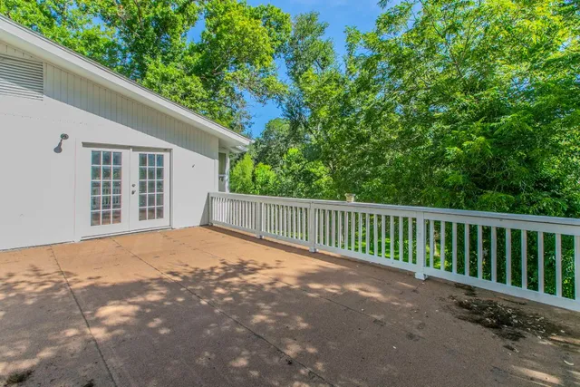 a view of a house with a big yard and palm trees