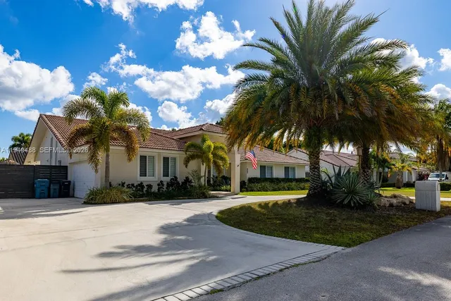 a front view of a house with a garden and trees