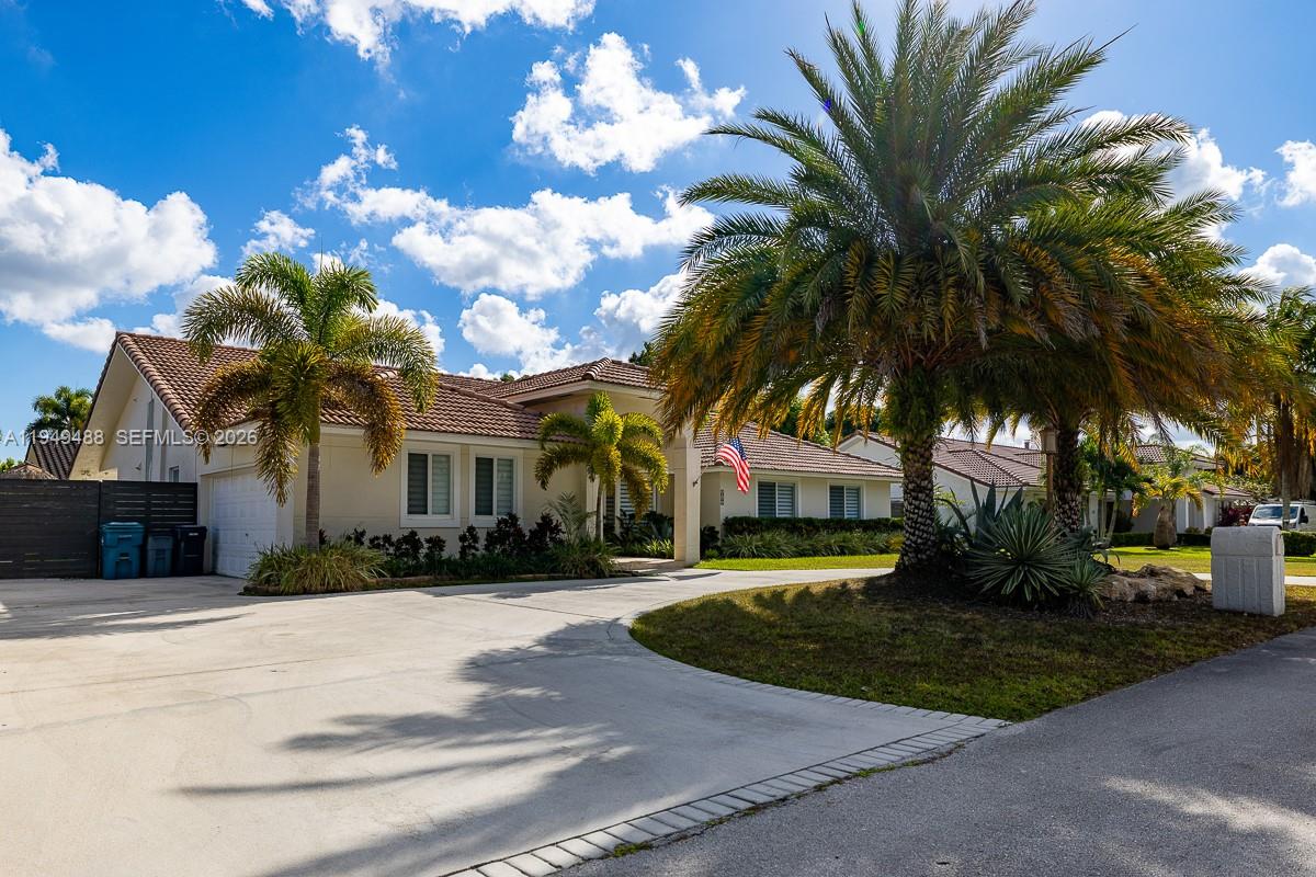 a front view of a house with a garden and trees