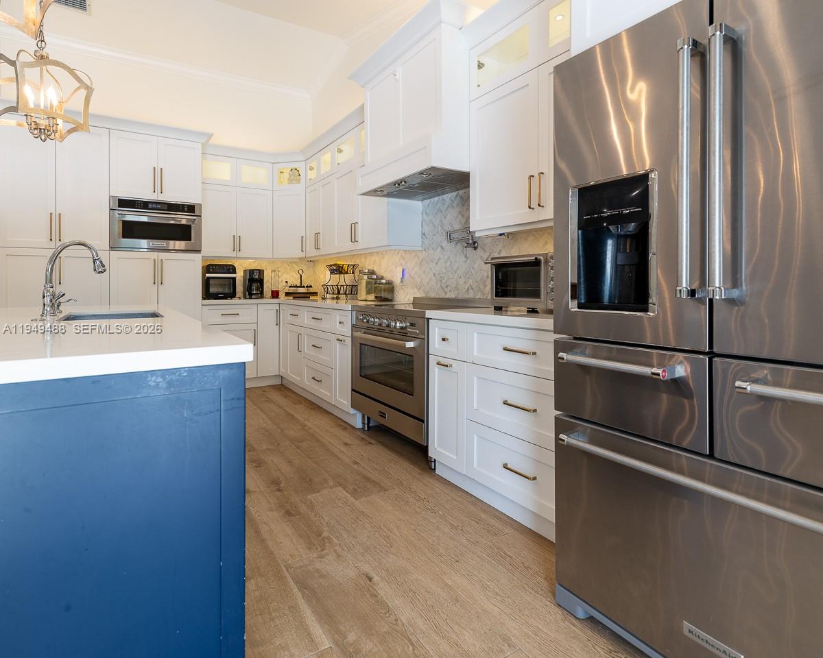 16141 Southwest 156th Avenue Miami, FL 33187 - Photo 11 of 35 a kitchen with stainless steel appliances white cabinets and a refrigerator
