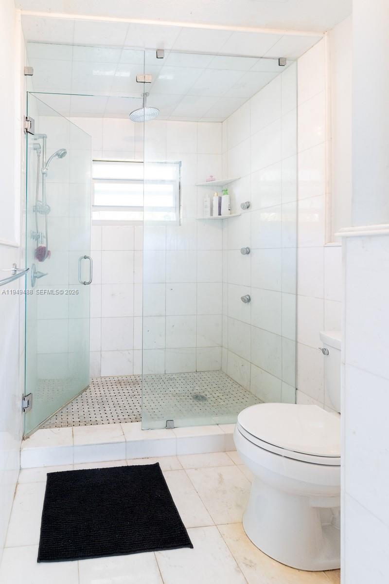 16141 Southwest 156th Avenue Miami, FL 33187 - Photo 18 of 35 a bathroom with a shower a toilet and a window