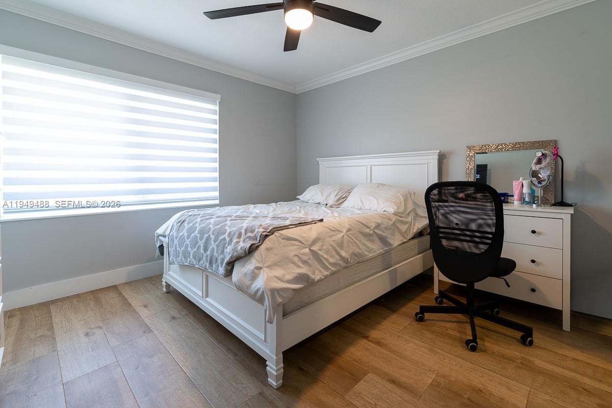 16141 Southwest 156th Avenue Miami, FL 33187 - Photo 22 of 35 a bedroom with a bed and a chandelier