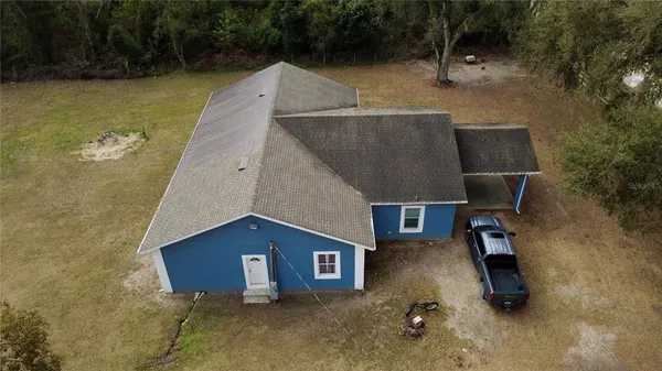 an aerial view of a house with swimming pool and patio