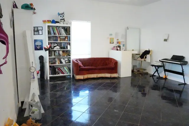 a living room with furniture a rug and a book shelf