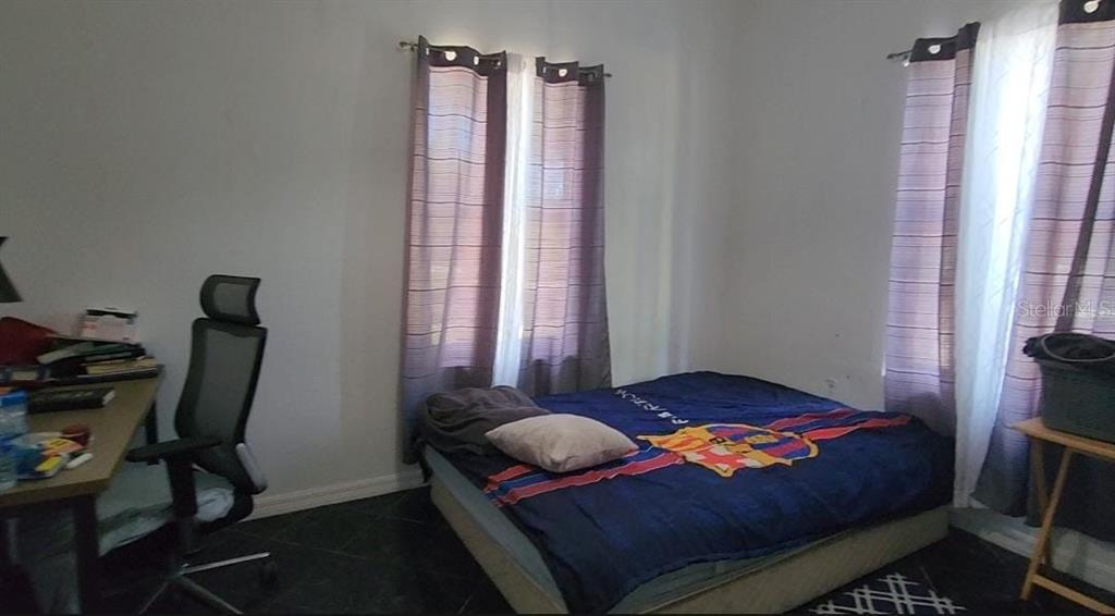 7040 Lumberton Road Zephyrhills, FL 33540 - Photo 8 of 34 a bedroom with a bed a chair and a window