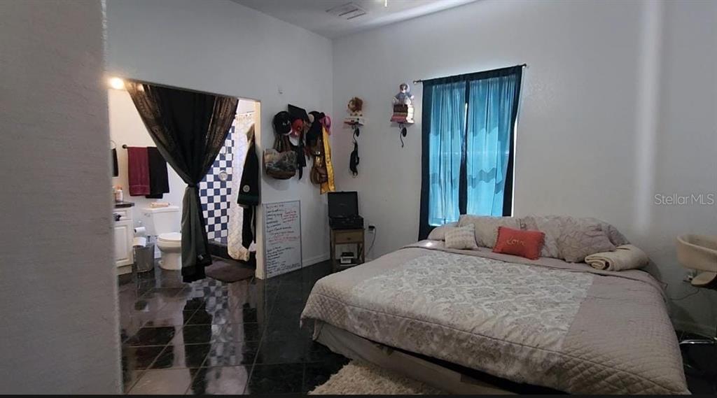 7040 Lumberton Road Zephyrhills, FL 33540 - Photo 9 of 34 a bedroom with a bed and a large mirror