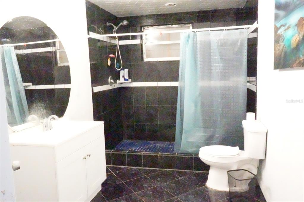 7040 Lumberton Road Zephyrhills, FL 33540 - Photo 10 of 34 a bathroom with a sink toilet and shower