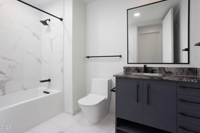 a bathroom with a granite countertop sink a toilet and shower