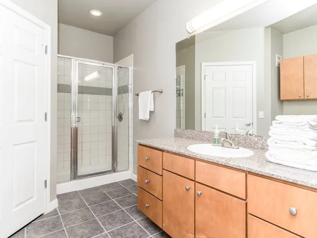 a spacious bathroom with a shower sink and mirror