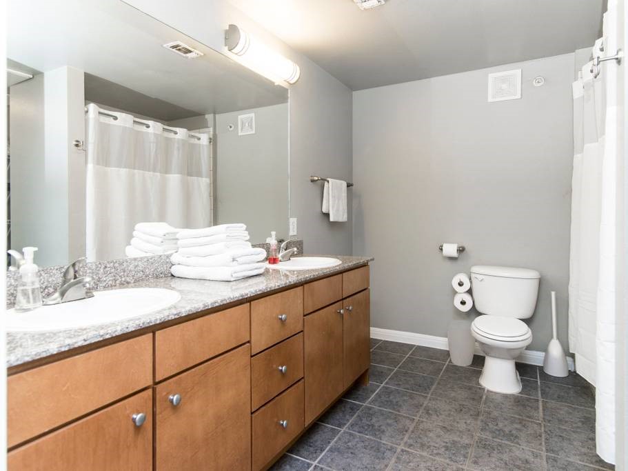 2502 Leon Street, Unit 217 Austin, TX 78705 - Photo 2 of 6 a bathroom with a granite countertop sink toilet and mirror