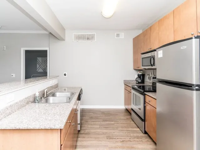 a kitchen with granite countertop a sink stove and refrigerator