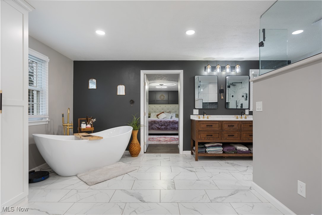2119 Devonshire Road Northwest Canton, OH 44708 - Photo 28 of 46 Beautiful newly renovated owners ensuite bathroom featuring lovely tile flooring, recessed lighting, stand alone tub, double sinks, and spacious closet
