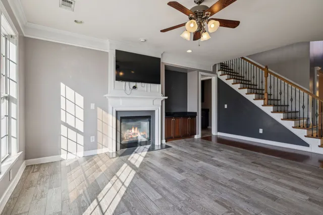 a view of an empty room with a kitchen and a window