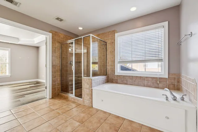 an empty room with wooden floor closet and windows