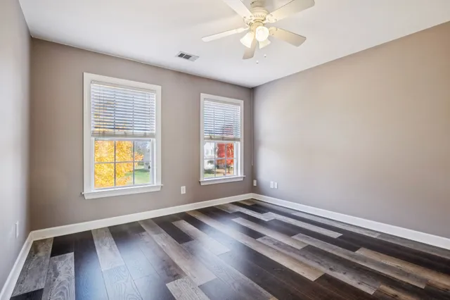 a view of a livingroom with wooden floor and a ceiling fan