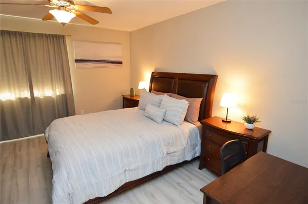 a view of a lake with a bench and trees in the background