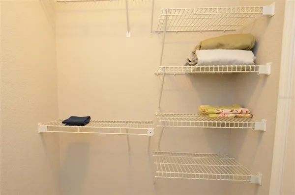 a view of swimming pool with seating space and trees in the background