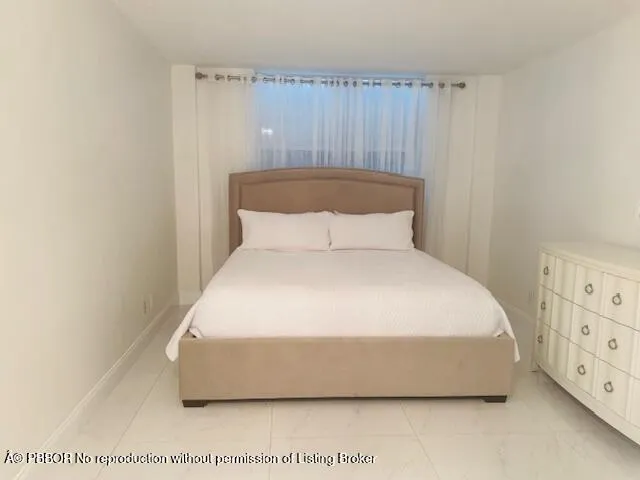a large bed sitting in a bedroom next to a window
