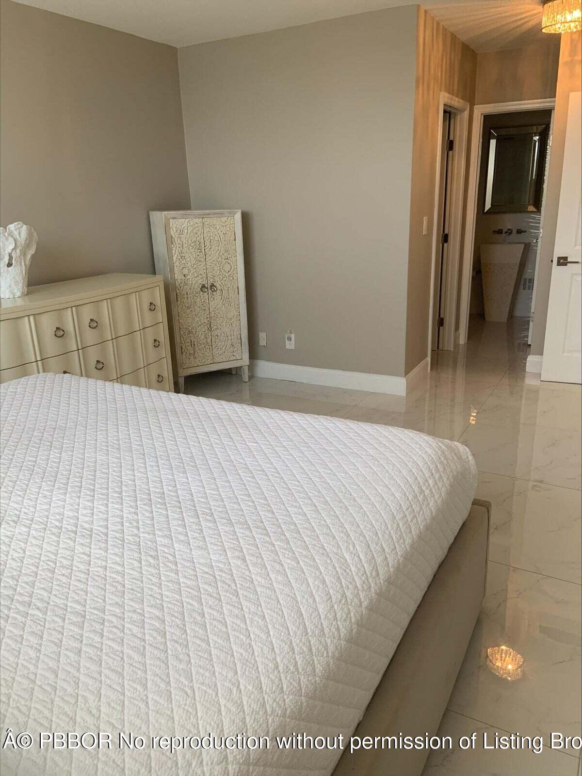 2840 South Ocean Boulevard, Unit 3170 Palm Beach, FL 33480 - Photo 13 of 30 a large bed sitting in a bedroom and a table