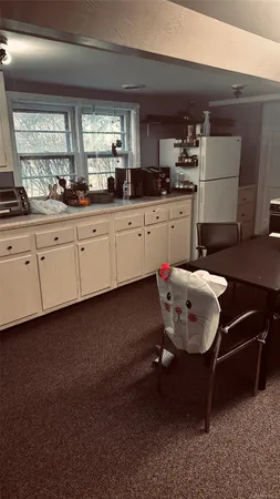 a kitchen with granite countertop a sink cabinets and wooden floor