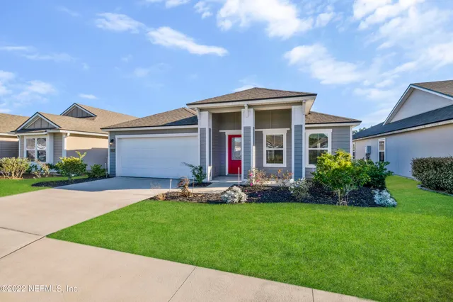 a front view of a house with a garden and yard