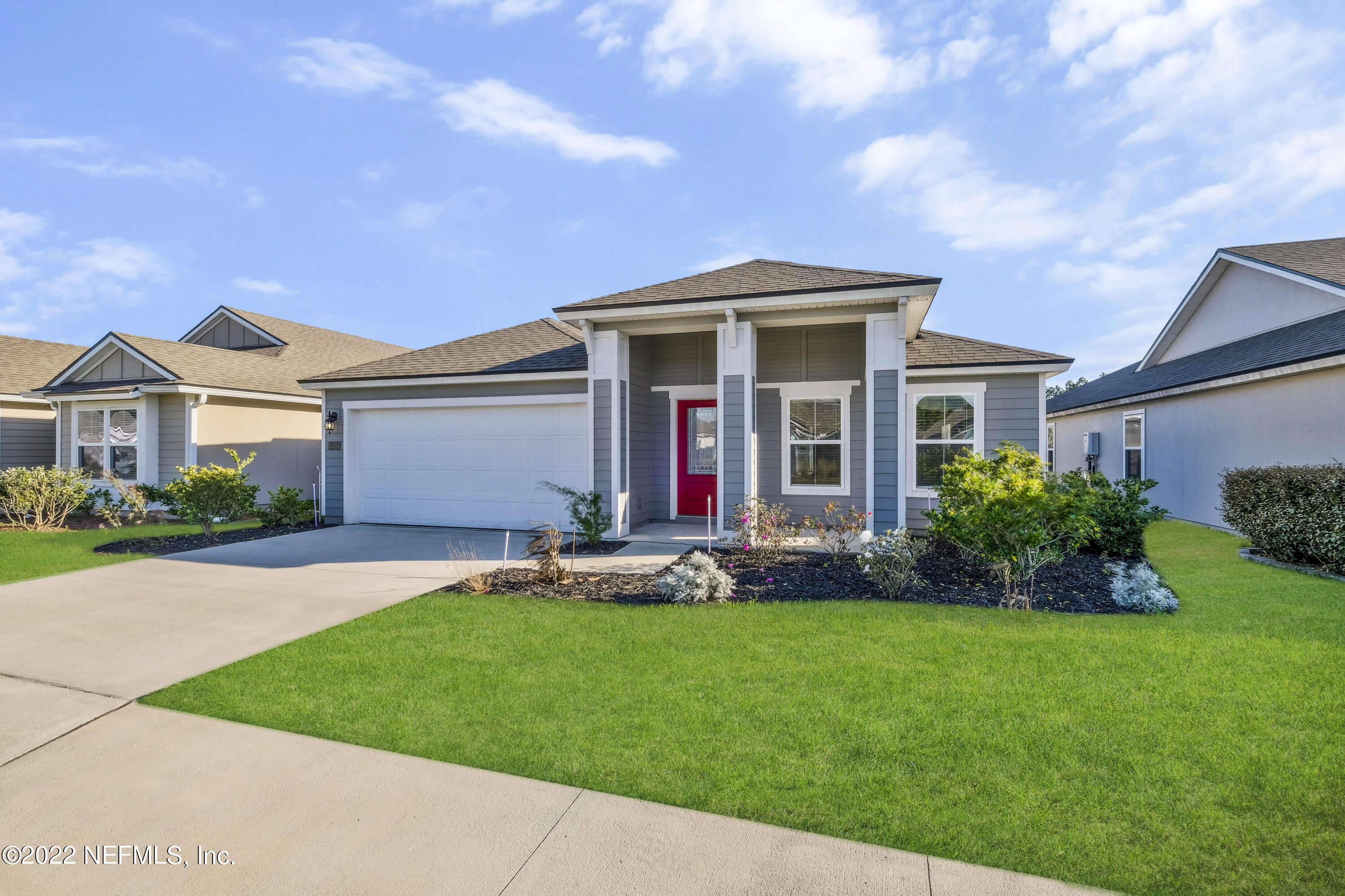 a front view of a house with a garden and yard
