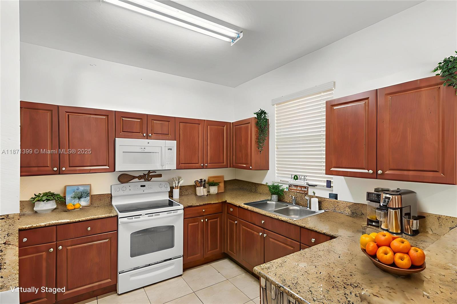 12958 Southwest 135th Street Miami, FL 33186 - Photo 3 of 14 a kitchen with stainless steel appliances stove microwave refrigerator sink and cabinets