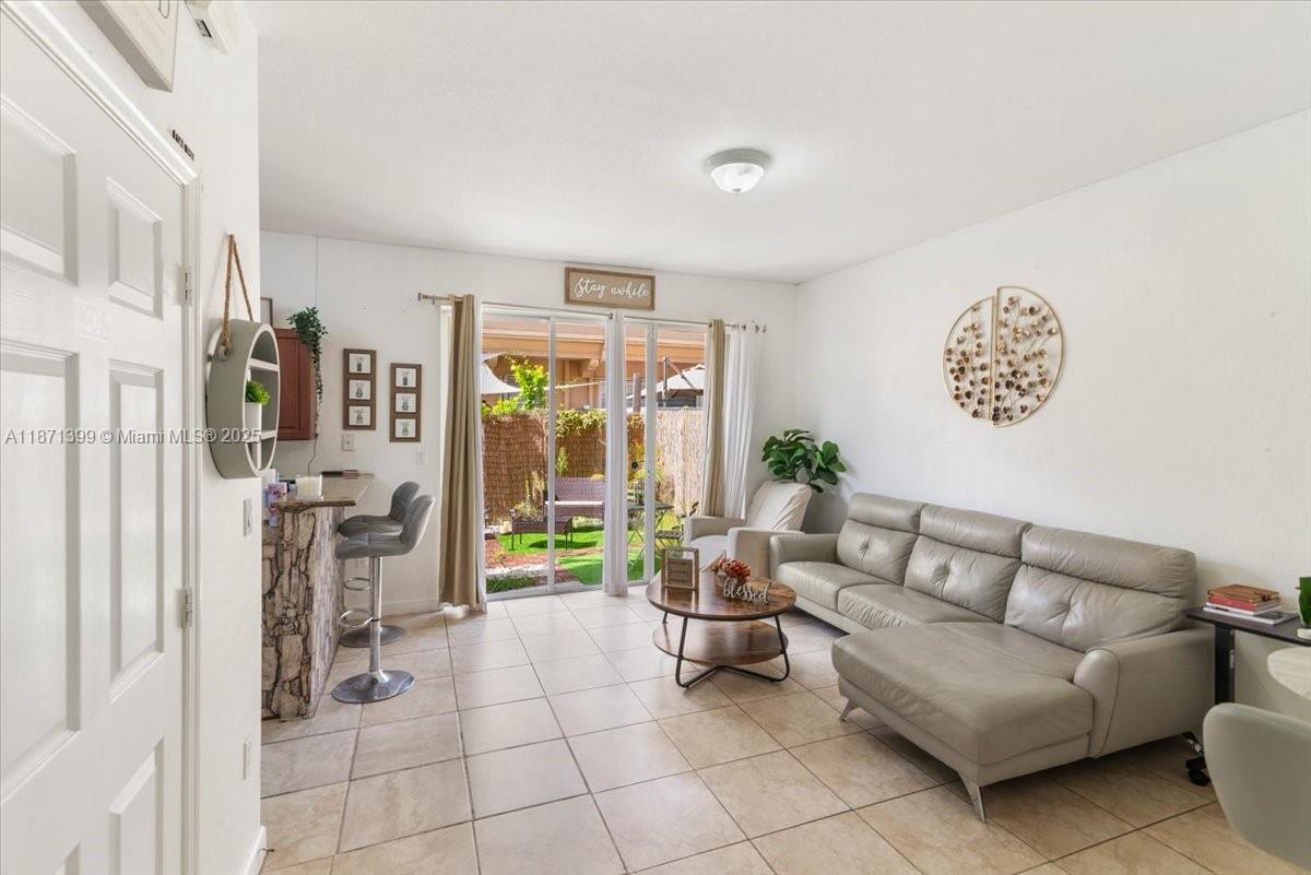 12958 Southwest 135th Street Miami, FL 33186 - Photo 6 of 14 a living room with furniture and a floor to ceiling window