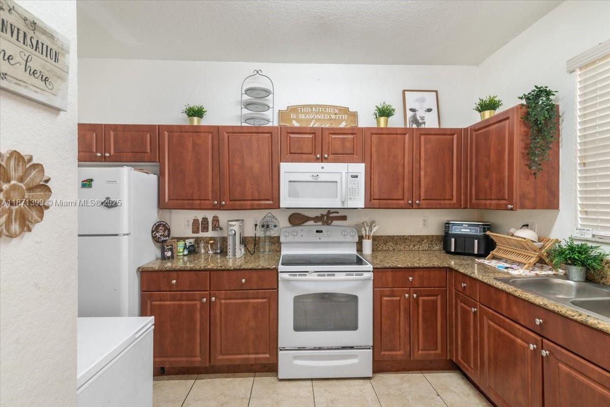 12958 Southwest 135th Street Miami, FL 33186 - Photo 7 of 14 a kitchen with a cabinets and white appliances