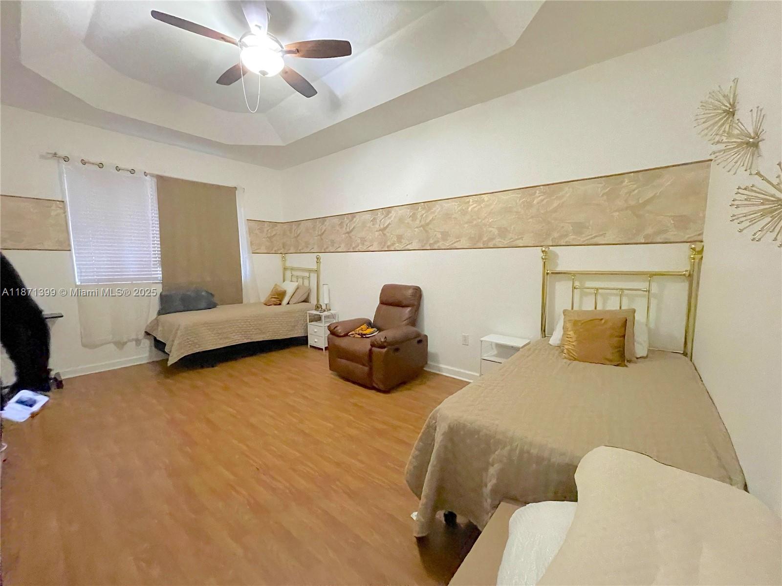 12958 Southwest 135th Street Miami, FL 33186 - Photo 9 of 14 a bedroom with two beds and painting on the wall