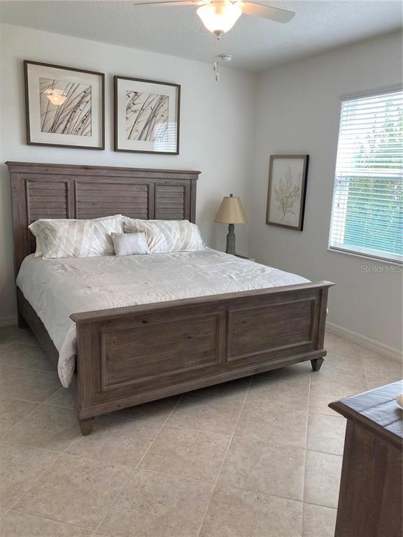 9877 Southwest 99th Loop Ocala, FL 34481 - Photo 7 of 10 a spacious bedroom with a bed and wall painting