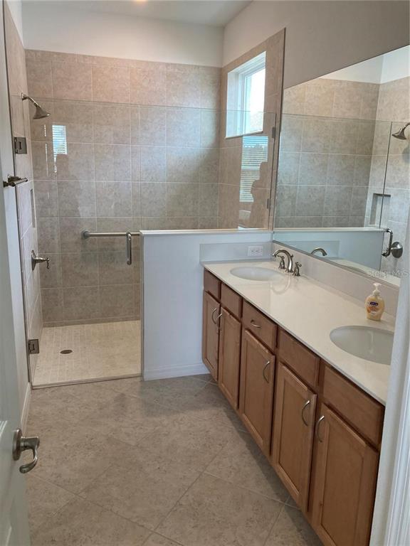 9877 Southwest 99th Loop Ocala, FL 34481 - Photo 8 of 10 a bathroom with a double vanity sink mirror and shower