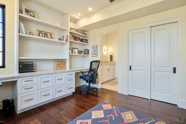 a roof deck with table and chairs with wooden floor and fence
