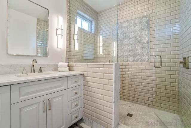 a living room with couches and a view of kitchen