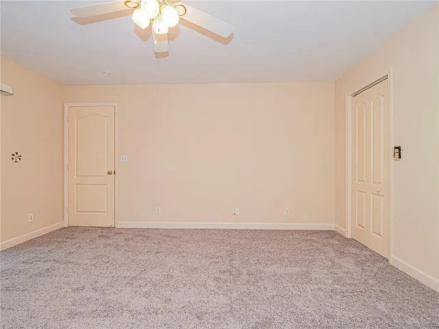 a view of an empty room with a chandelier fan