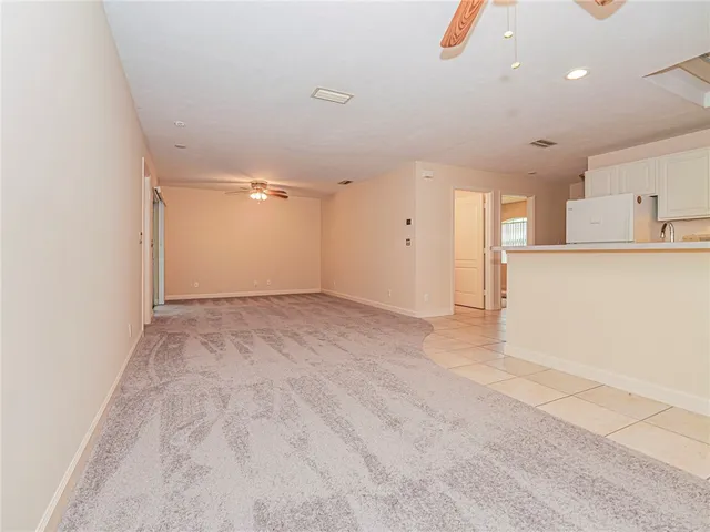 an empty room with a window and a ceiling fan