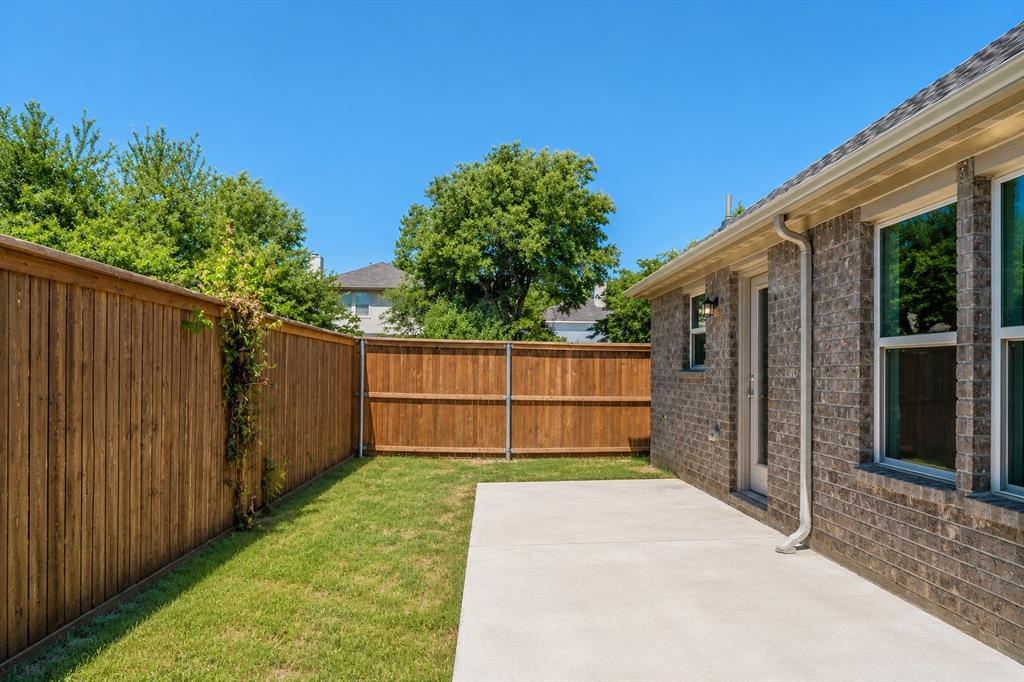 3344 Duncan Way Corinth, TX 76210 - Photo 26 of 38 Spacious backyard featuring a concrete patio, manicured lawn, and a privacy fence