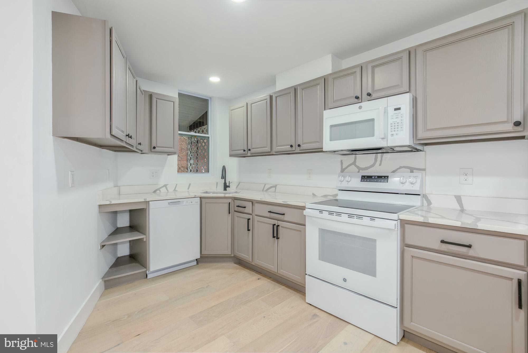 745 Kenyon Street Northwest Washington, DC 20010 - Photo 7 of 27 a kitchen with granite countertop white cabinets white stainless steel appliances and sink