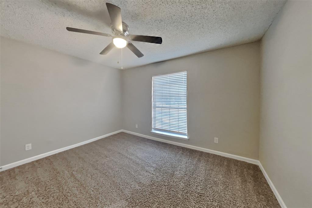 3817 Rochelle Drive Arlington, TX 76016 - Photo 15 of 25 an empty room with chandelier fan and windows