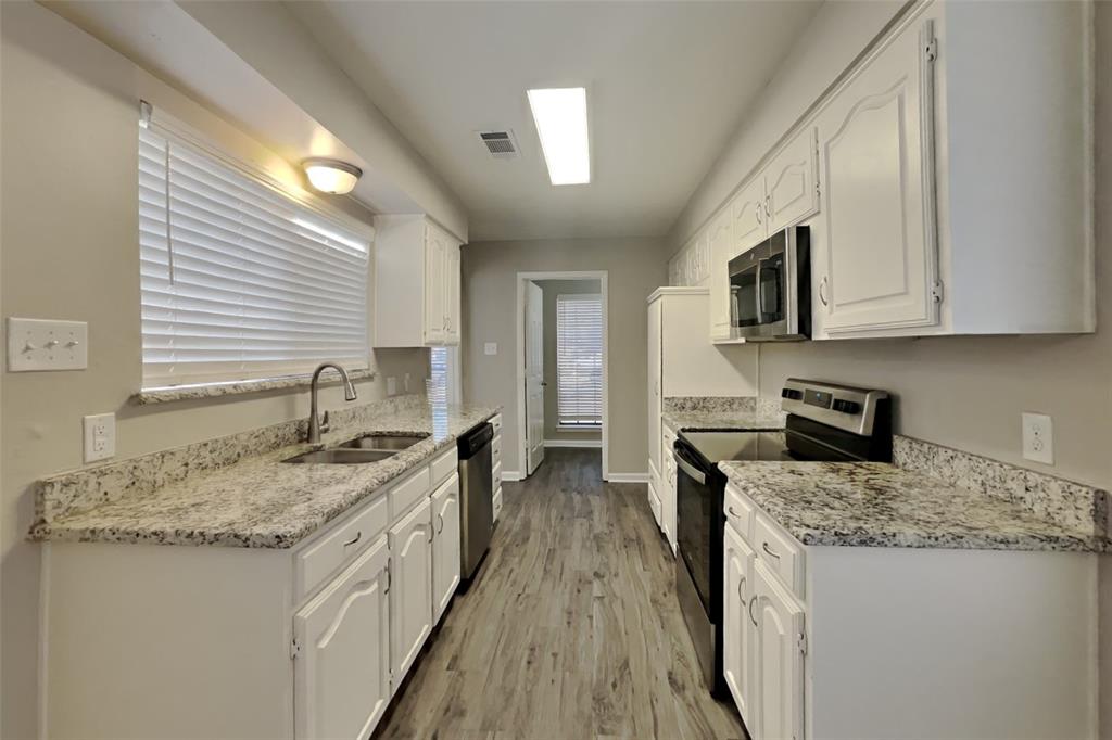 3817 Rochelle Drive Arlington, TX 76016 - Photo 6 of 25 a kitchen with granite countertop a sink a stove top oven a counter space and cabinets