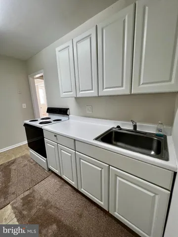 a kitchen with white cabinets and white appliances