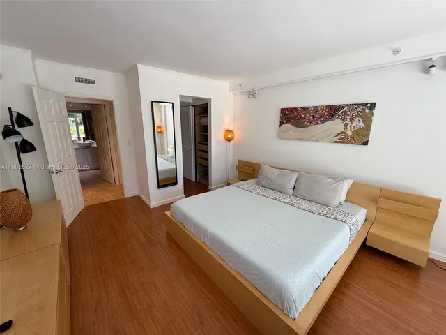 a bedroom with a bed and wooden floor