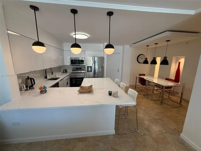 a kitchen with a sink a counter and chairs