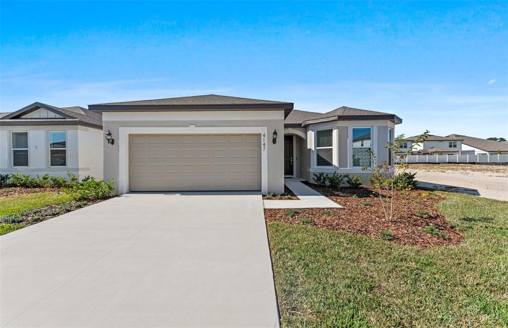 4147 Feldspar Lane Spring Hill, FL 34609 - Photo 1 of 22 a front view of a house with a yard and garage