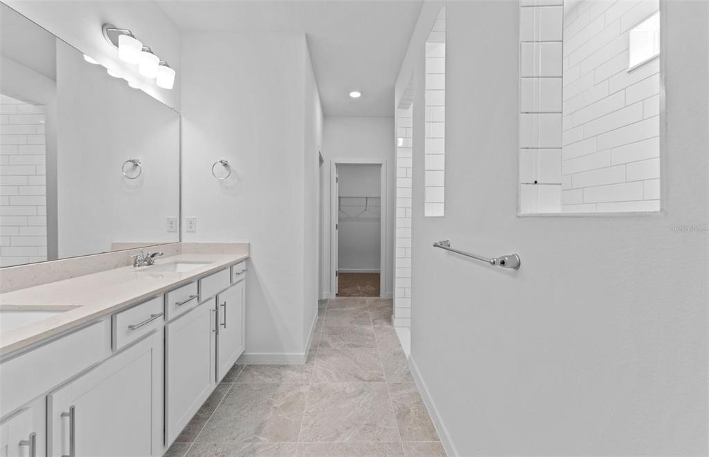 4147 Feldspar Lane Spring Hill, FL 34609 - Photo 9 of 22 a bathroom with a double vanity sink and mirror